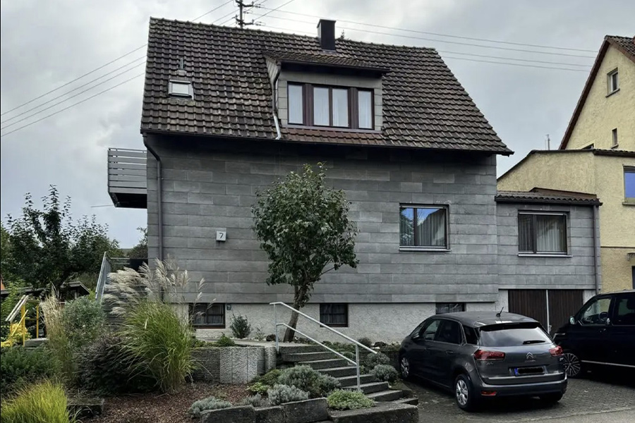 Einfamilienhaus mit Auto vor dem Haus